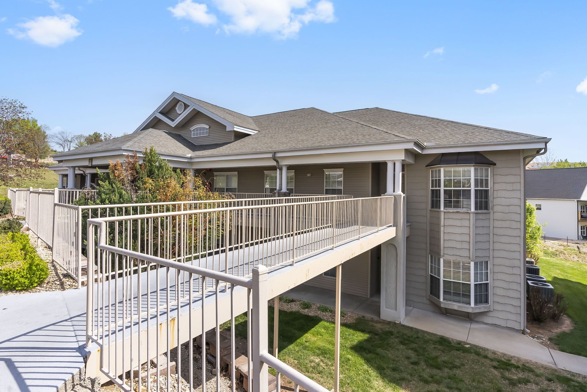 A two-story house with a covered patio and a small deck.