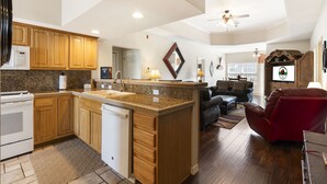 A modern kitchen with wooden cabinets, a granite countertop, and a built-in dishwasher. - Group Getaway • 4BR with Balcony & Golf Discounts (Branson)