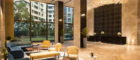 A modern lobby with seating areas, large windows, and a reception desk.