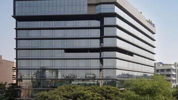 A modern multi-story building with reflective glass windows, a flat roof, and a visible sign indicating it is a hotel.