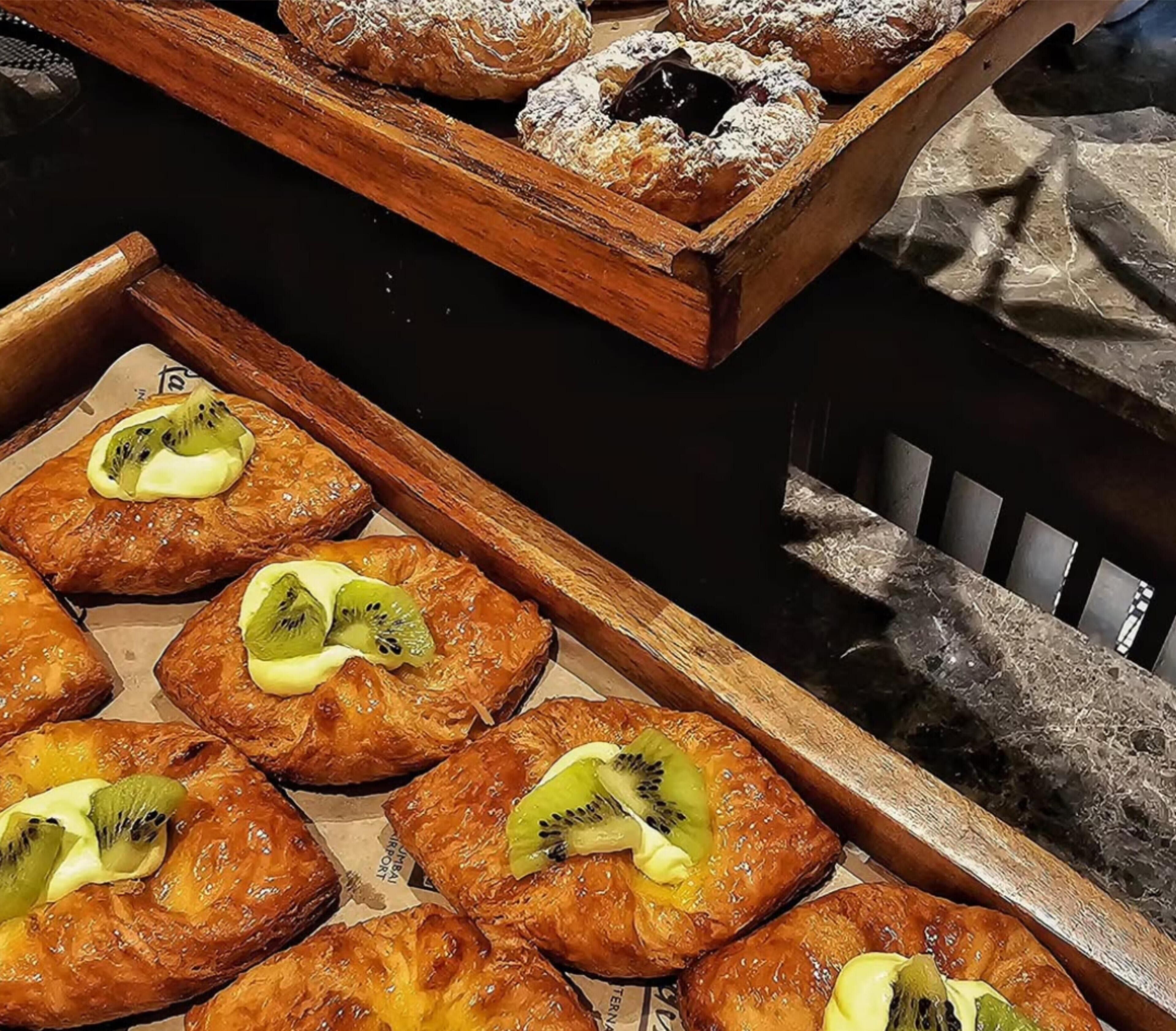 Una bandeja de pasteles con rodajas de kiwi por encima.