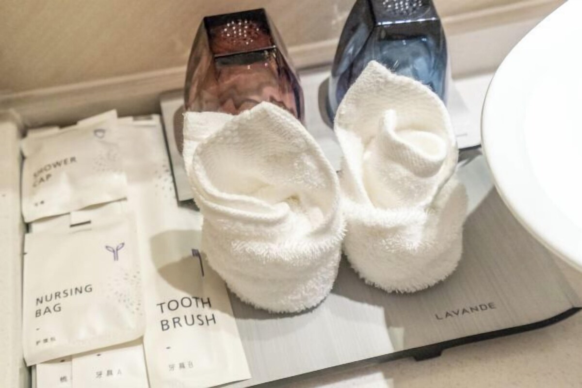 A bathroom with a shower cap, a nursing bag, a tooth brush, and a lavender soap.