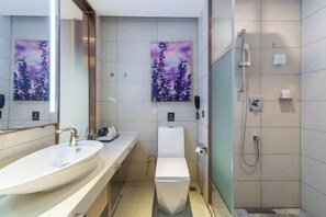 Un baño moderno con lavamanos, inodoro y ducha.