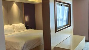 A hotel room with a bed, a bedside table, a wall-mounted TV, and a window. - Zhongfa Hotel (Linxiang)
