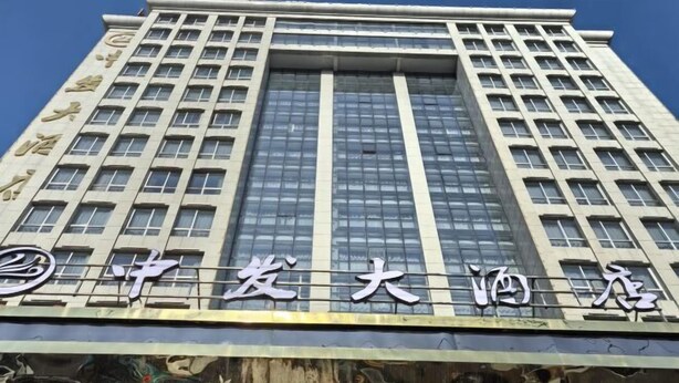 A tall building with a modern architectural design, featuring a prominent sign with Chinese characters. - Zhongfa Hotel (Linxiang)