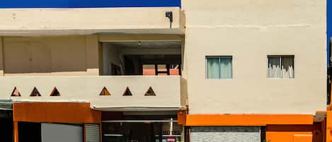 A hotel with a flat facade, a ground-level entrance, and a visible sign indicating it is a hotel.