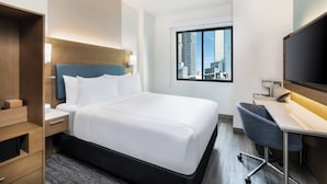 A modern hotel room with a large bed, a desk, a chair, and a television. - EVEN Hotel Long Island City - New York by IHG (Long Island City)