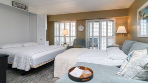 A hotel room with two beds, a sofa, a small table with a tray, and a 'BEACH' sign on the wall. - Ocean View Escape Studio Condo (Rehoboth Beach)