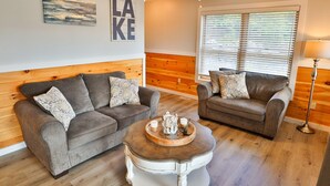 A cozy living room with two grey sofas, a wooden coffee table, and a ceiling fan. - La Bella Vita in Bolton Landing (Bolton Landing)