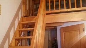 Eine Holztreppe mit Geländer, die zu einer Tür führt.