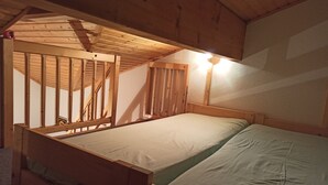Ein Stockbett mit Holzgestell und einer Matratze.