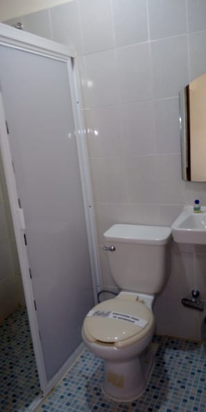 Een badkamer met toilet, wastafel en betegelde vloer.