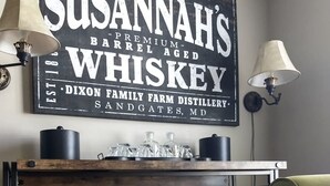 A rustic wooden shelf with whiskey bottles and a vintage whiskey pump. - Historic, Elegant, Luxurious. (Mechanicsville)