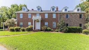 A large brick building with a central entrance, multiple windows, and a well-maintained lawn. - Historic, Elegant, Luxurious. (Mechanicsville)