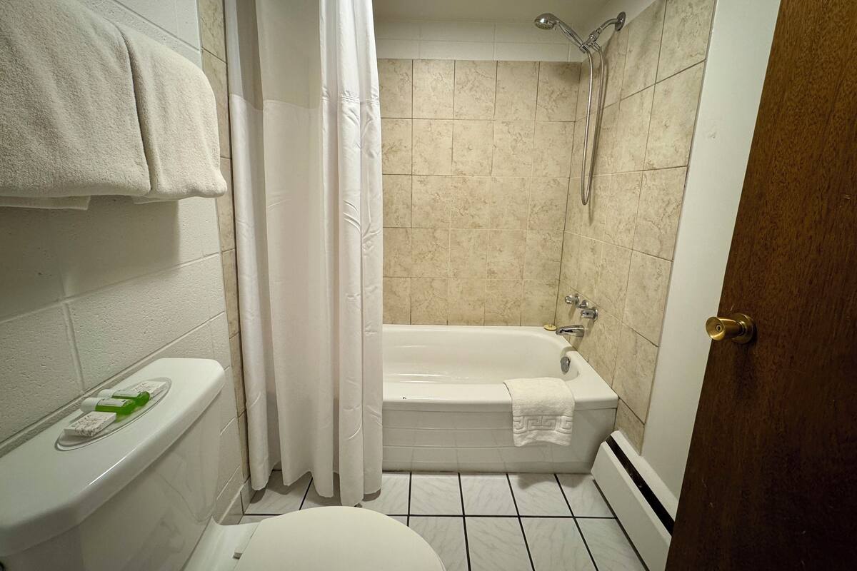 Un baño con bañera, inodoro y ducha.