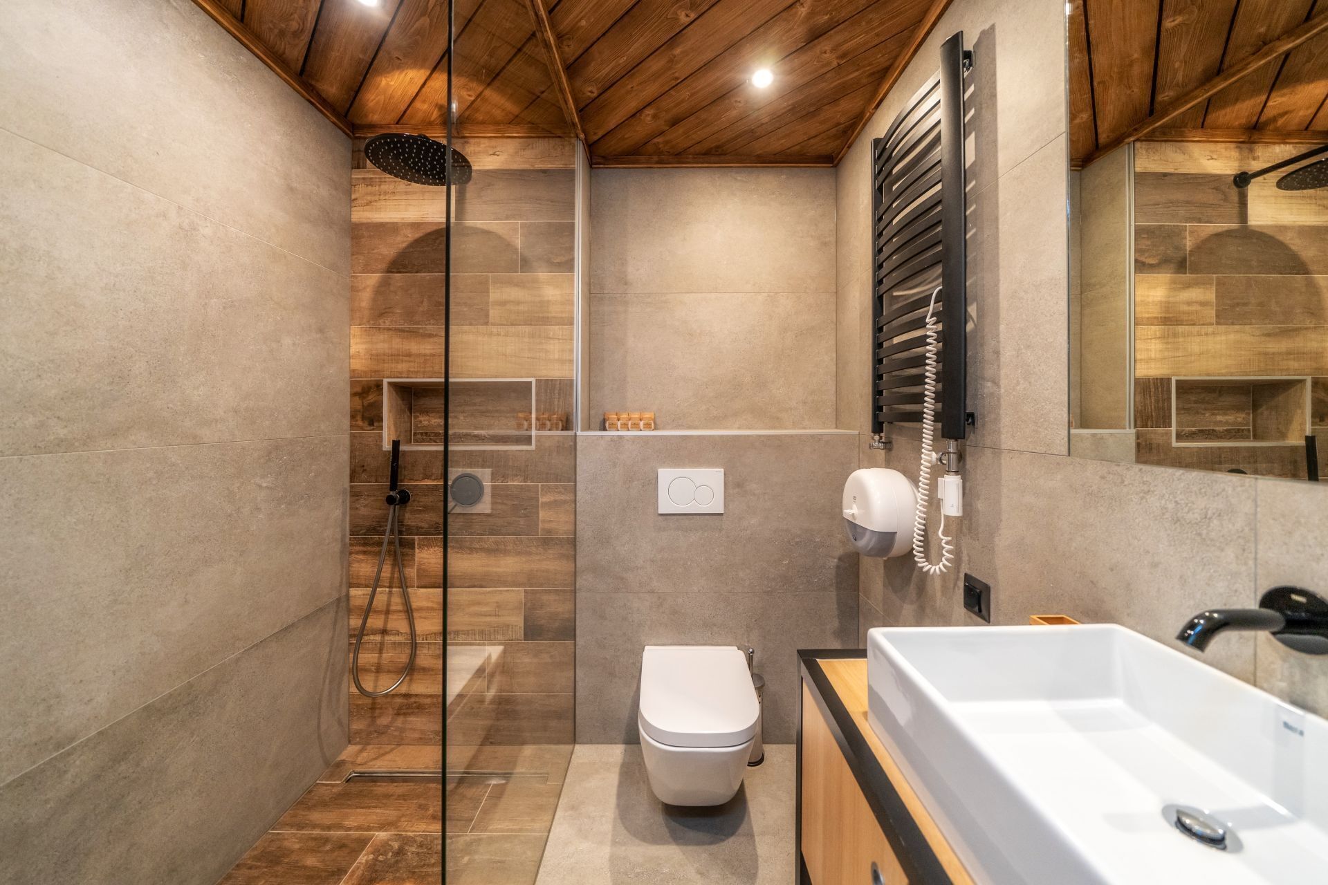 A modern bathroom with a shower, toilet, and sink.