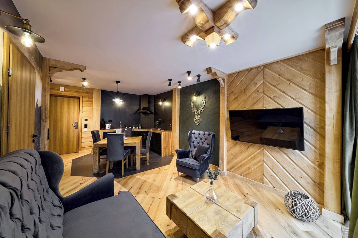 A modern living room with a sofa, a coffee table, and a dining area with chairs and a table.