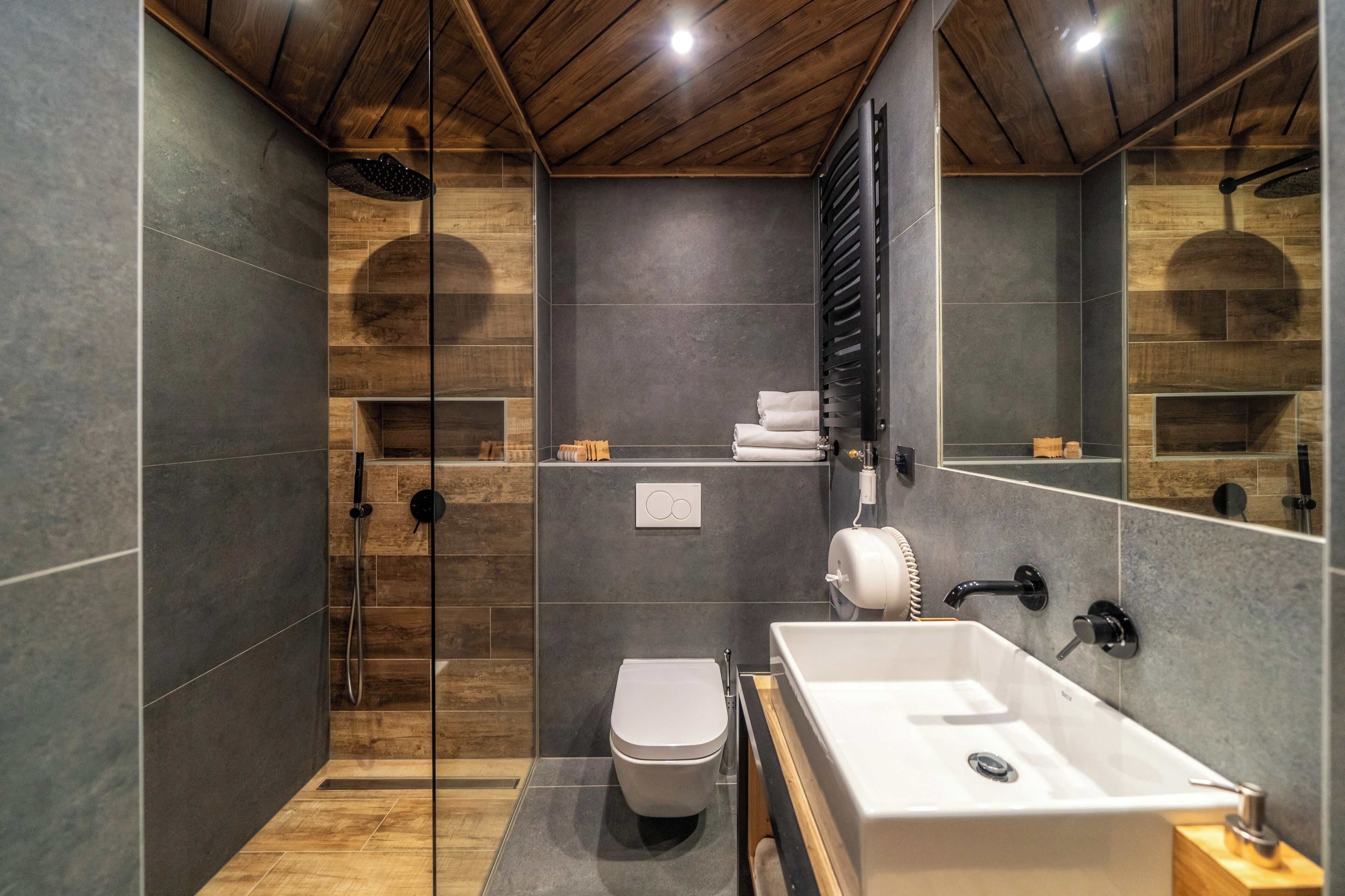A modern bathroom with a shower, toilet, and sink.