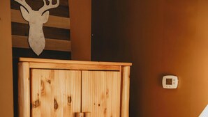 Un armario de madera con varios cajones y una pequeña mesa con una lámpara y un libro.