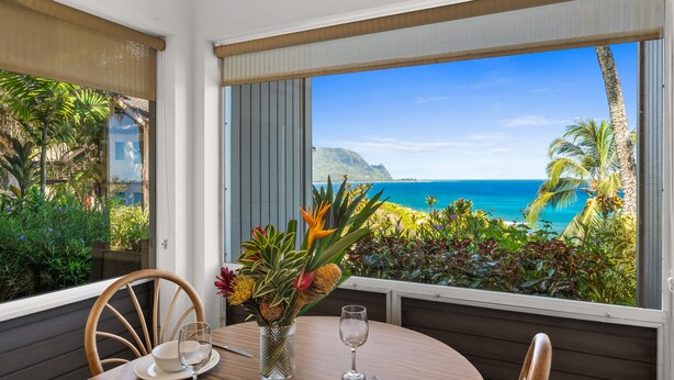 Une table à manger avec vue sur l’océan et les montagnes.