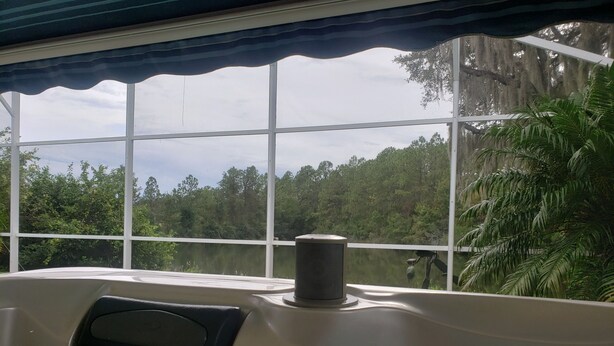 Un bain à remous avec vue sur une forêt, grâce à de grandes fenêtres.