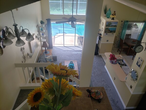 A home interior with a staircase, a dining area, and a view of a backyard with a pool.