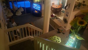 Un espace de vie à plusieurs niveaux comprenant un coin repas, une cuisine et un escalier.