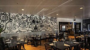 A restaurant with a mural on the wall, wooden flooring, and tables with chairs. - Main Street | Walk to Shopping | Private Balcony (Park City)