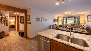 A modern kitchen with granite countertops, stainless steel appliances, and a dining area with a view. - Main Street | Walk to Shopping | Private Balcony (Park City)
