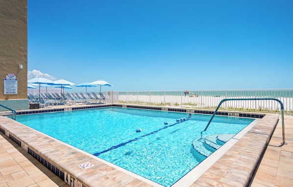 Une piscine rectangulaire avec des séparateurs de couloirs, une partie peu profonde signalée à 1,20 mètre et une profondeur de 2,10 mètres.