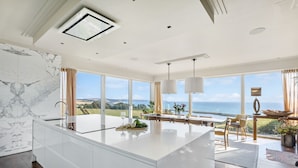 A modern kitchen with a large island, large windows, and a view of the sea. - Golden Meadow -  Views - Pet Friendly - Free Parkin - Free WiFi (Torcross)