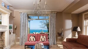 A living room with a sofa, a coffee table, and a view of the sea. - Golden Meadow -  Views - Pet Friendly - Free Parkin - Free WiFi (Torcross)