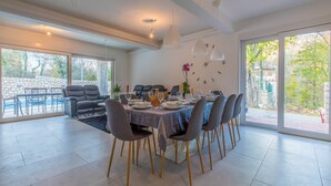 A spacious dining area with a large table set for six, surrounded by modern chairs with gold legs. - Villa Adry (Bribir)