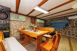 A room with a dartboard, a clock, a stone wall, and a mural. - Villa Adry 2 (Bribir)