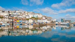 Une ville côtière avec des bâtiments qui bordent le front de mer et des bateaux amarrés dans l’eau.