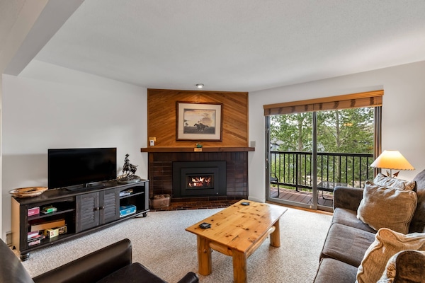 Cozy up by the fire in this charming mountain living room.