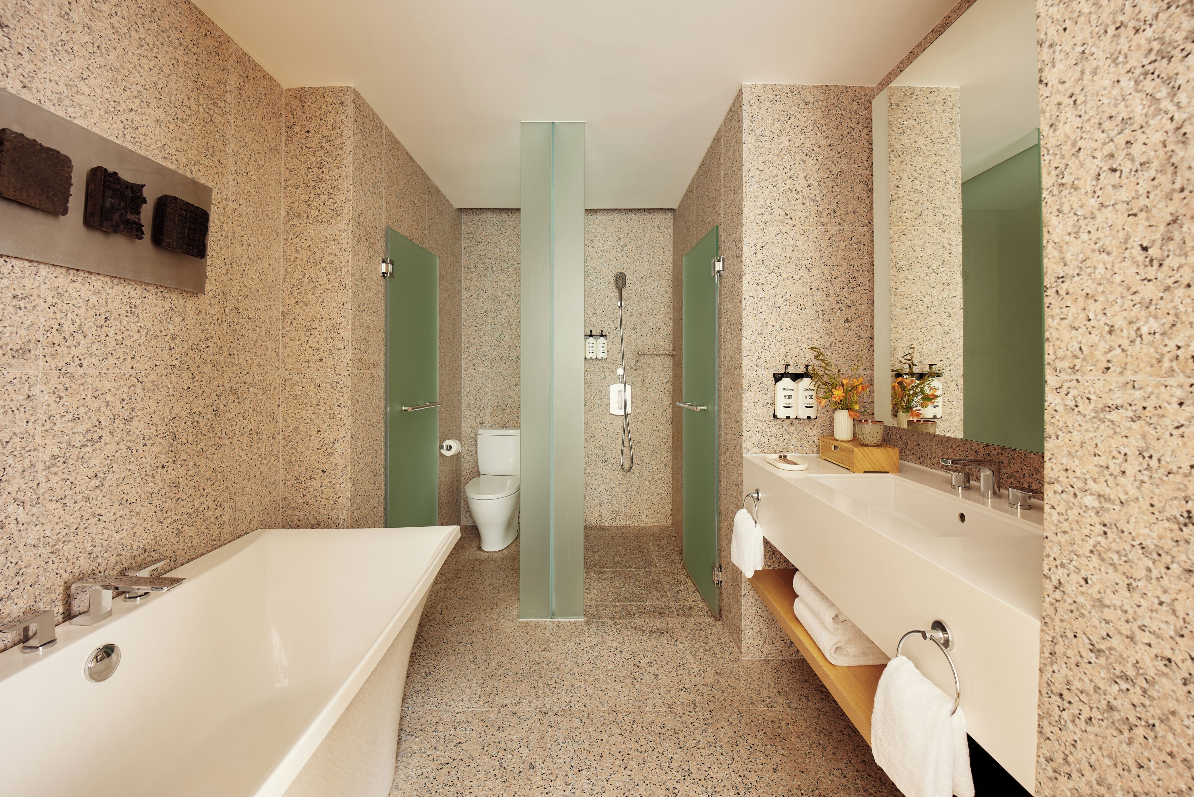 Un baño moderno con bañera, dos lavamanos, inodoro y ducha.