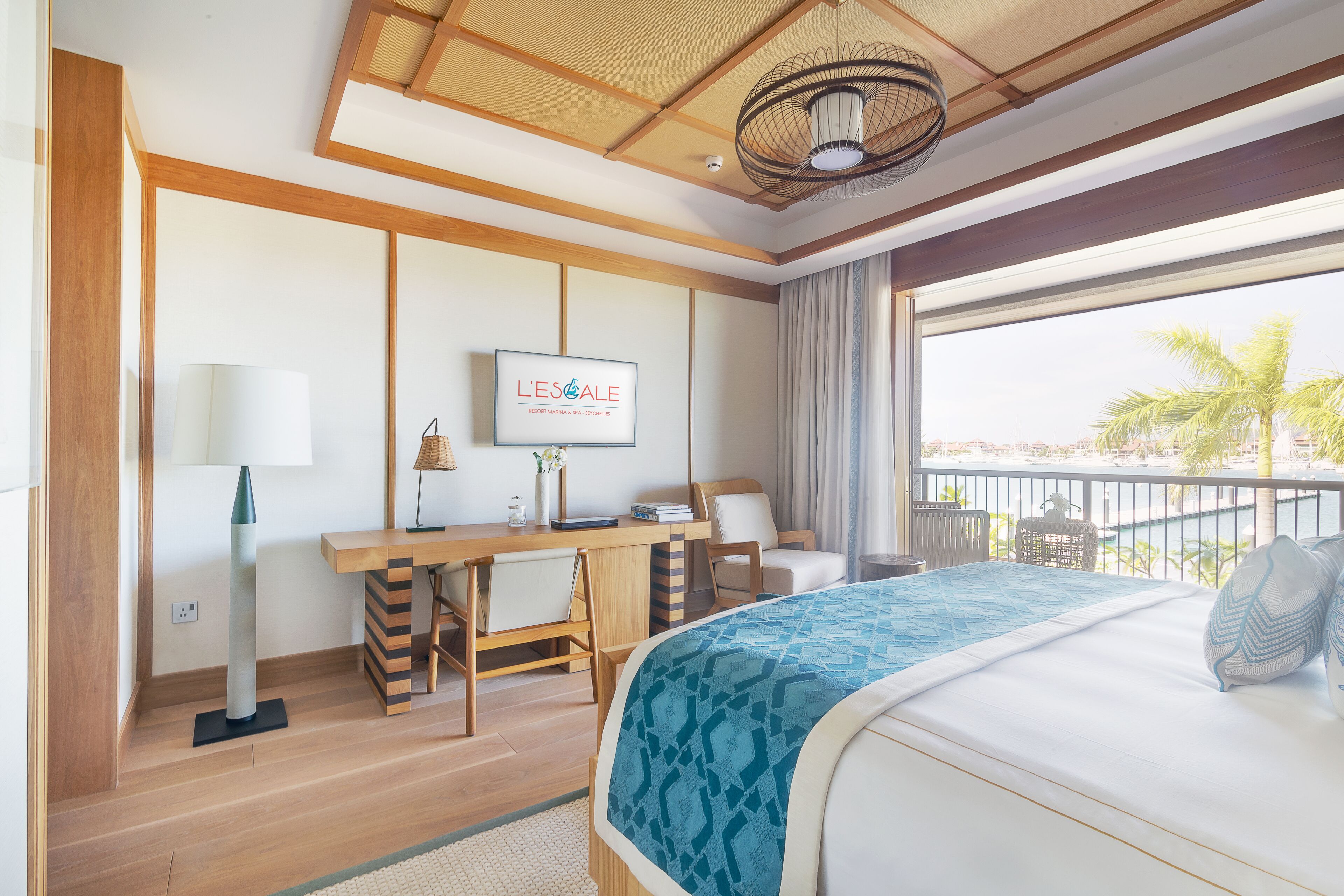 Et hotelværelse med seng, skrivebord, stol, fjernsyn og udsigt ud af vinduet.