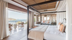 A spacious bedroom with a large bed, a balcony with seating, and a view of the sea. - L'Escale Resort Marina & Spa (Mahé Island)