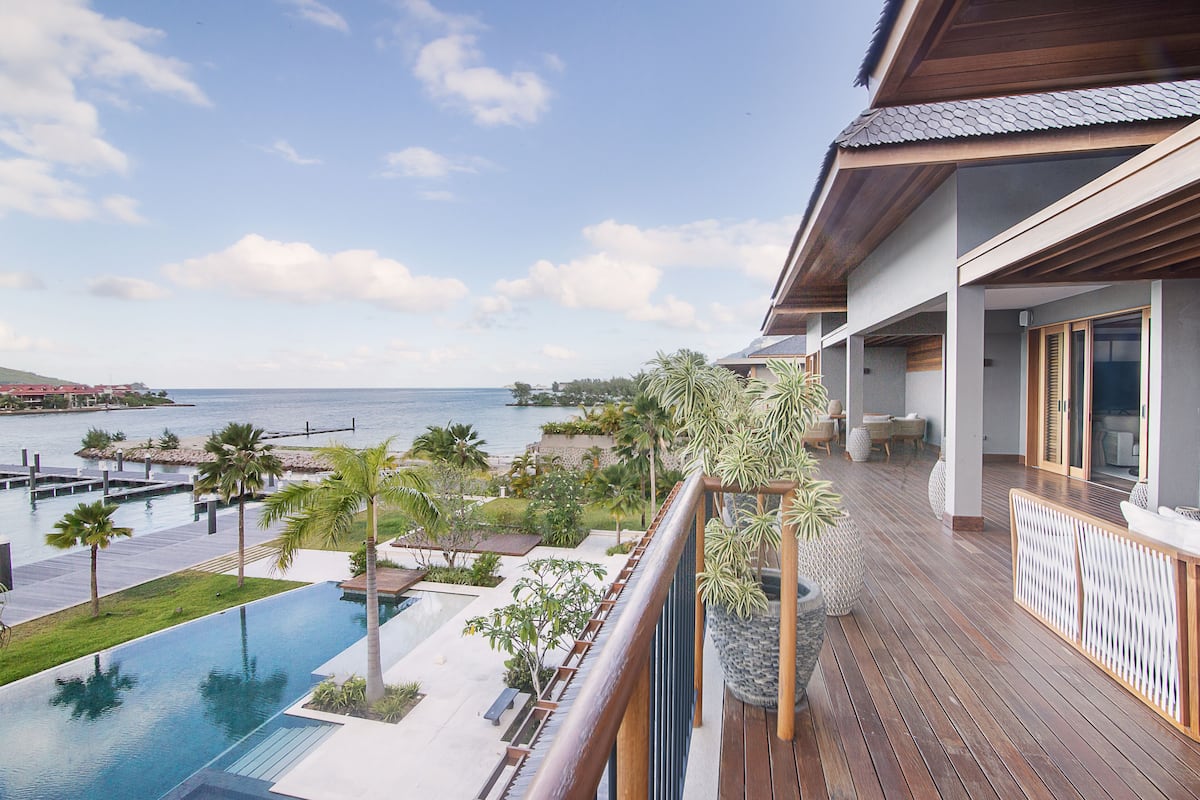 A resort with a wooden deck, a pool, and a view of the ocean.