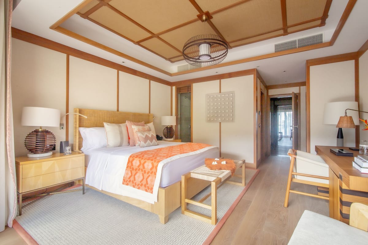 A traditional Japanese-style bedroom with a bed, bedside tables, a desk, and a chair.