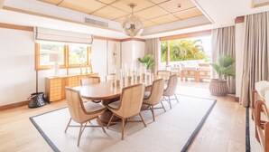 A spacious dining area with a large round table, multiple chairs, and a view of the outdoors. - L'Escale Resort Marina & Spa (Mahé Island)