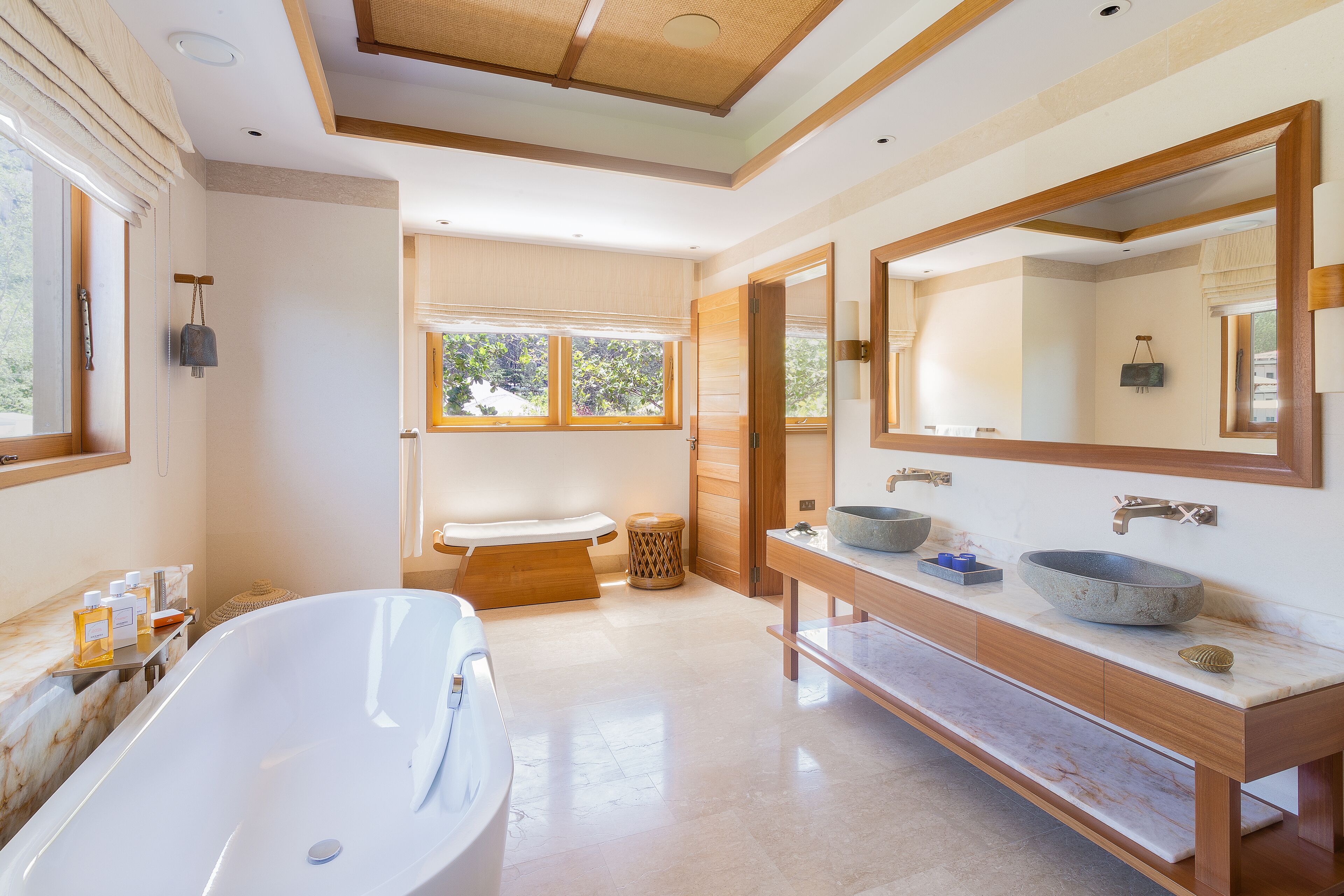 A modern bathroom with a freestanding bathtub, a double vanity with two sinks, and a large mirror.