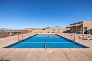 A rectangular swimming pool with a clear blue water surface, surrounded by a tiled deck.