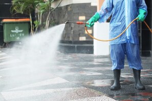 Una persona con equipo de protección usando una manguera de agua.