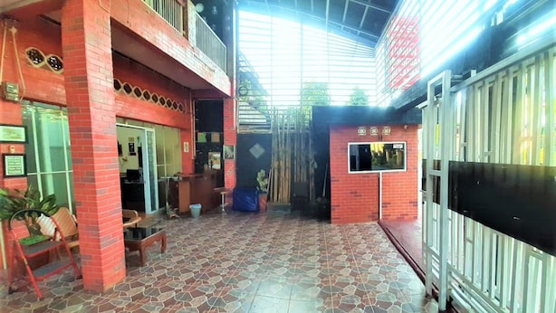 A spacious indoor area with a tiled floor, a balcony, and a gated entrance. - Katawa Guest House Syariah (Palembang)