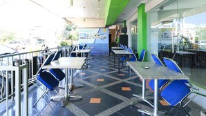 A restaurant with outdoor seating, tables, and chairs. - Al-badar Hotel Syariah Makassar by Zuzu (Makassar)