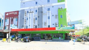 A hotel with multiple floors, a green and white facade, and a sign for 'Al-Badar Hotel'. - Al-badar Hotel Syariah Makassar by Zuzu (Makassar)