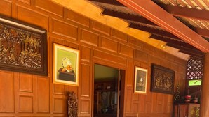 Quarto de madeira tradicional com uma cama, um banco e uma pequena mesa.