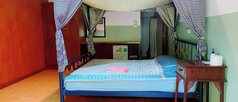 A room with a bed, a small table, and a cabinet.